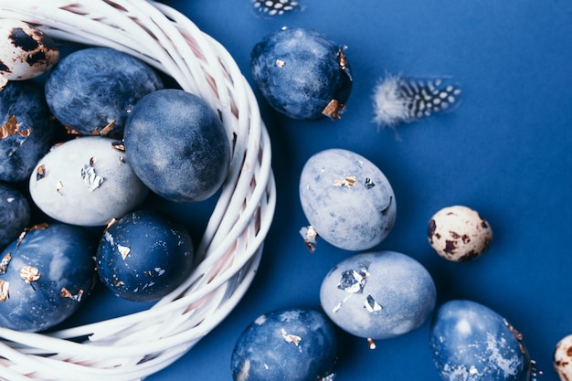 Blauwe kwartelseieren en bloemen op lichte achtergrond