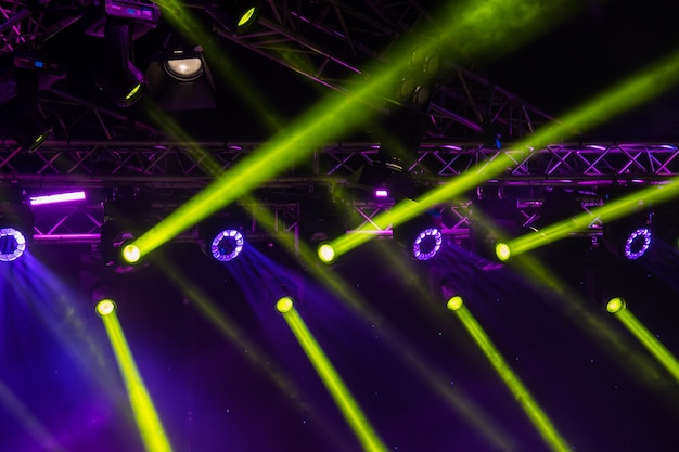 blauwe lichtgevende stralen van concertverlichting tegen een donkere achtergrond