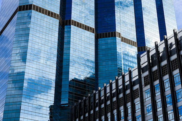 Blauwe lucht en wolken weerspiegeld op het glas van kantoorgebouwen in het stadscentrum op een zonnige dag