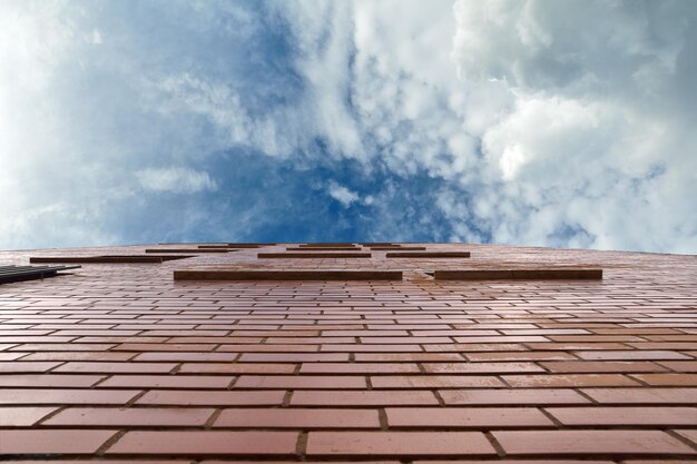 Blauwe lucht met daarop een rode bakstenen muur