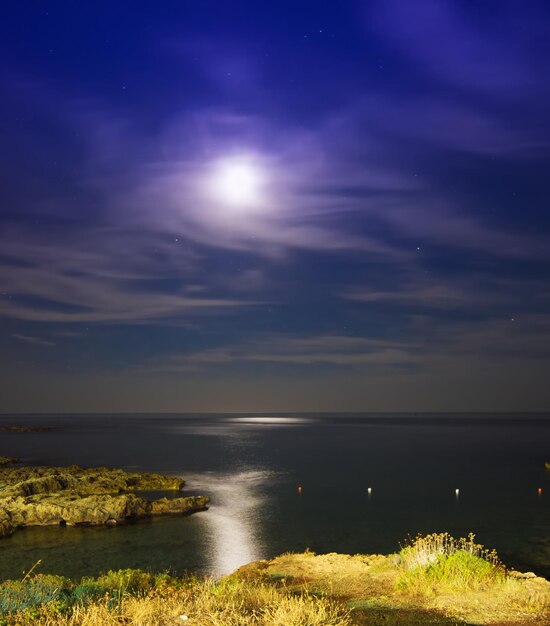 Blauwe lucht met maan en wolken in Alghero