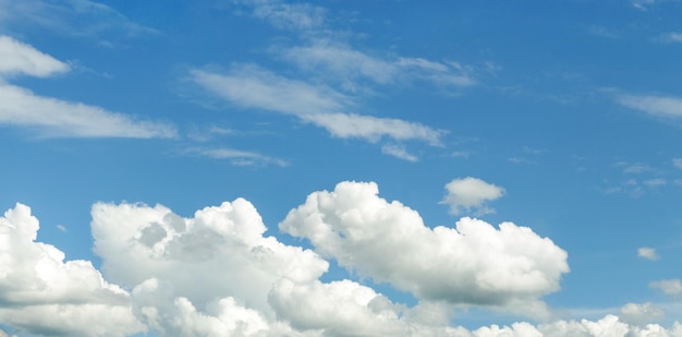 Blauwe lucht met pluizige wolken in zonnige zomerdag zonder grond voor achtergrond