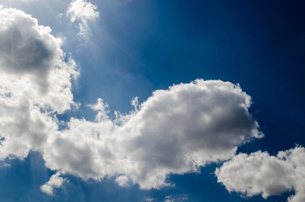 Blauwe lucht met witte wolken in zonnestralen