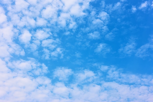 Blauwe lucht met witte wolken - vlekkerige gestructureerde achtergrond