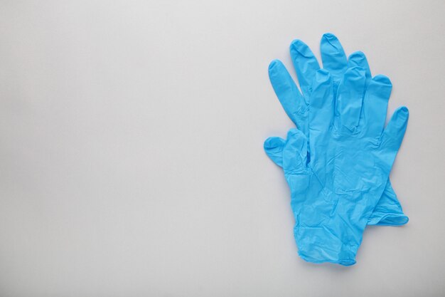 Blauwe medische handschoenen op een grijze achtergrond