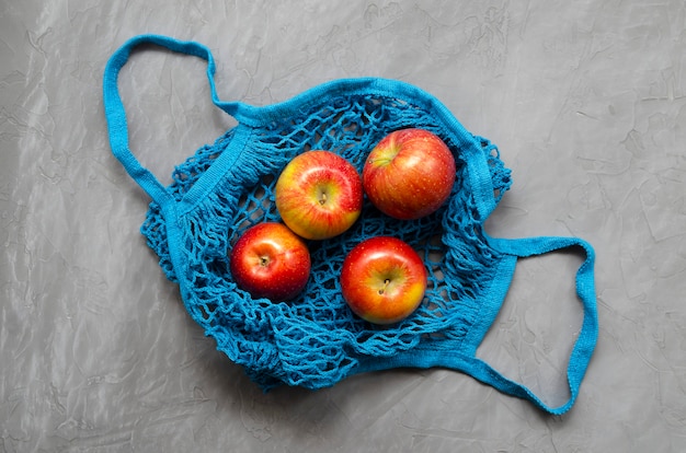 Blauwe mesh eco zero waste boodschappentas met fruitrode appels
