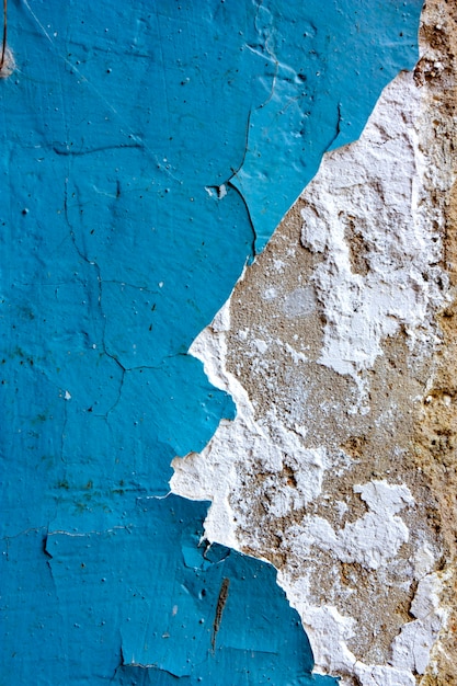 Blauwe oude afgebroken verf op een oude muurtextuur van een betonnen muur