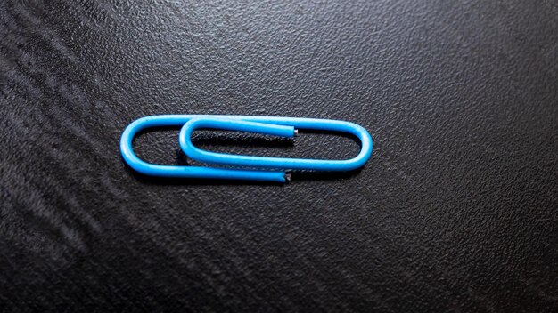 Blauwe paperclip op een houten tafel