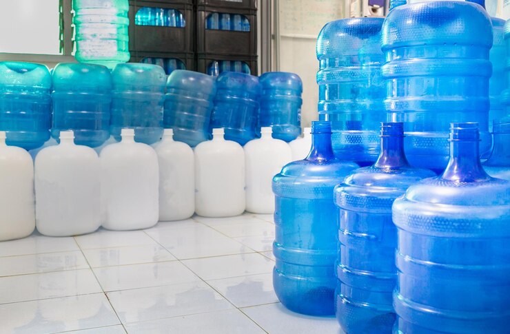 Blauwe plastic flessen of blauwe liters drinkwater worden gestapeld in de drinkwaterfabriek