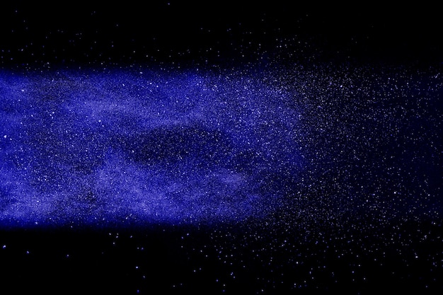 Blauwe poederexplosie op zwarte achtergrond.