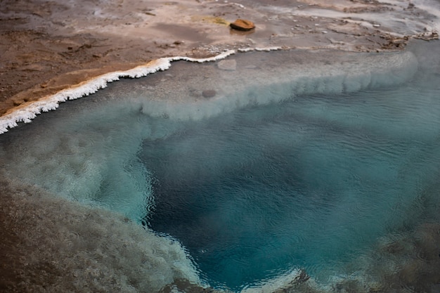 Blauwe pool van hete lente in geothermische streek dichtbij beroemde geiser in IJsland.