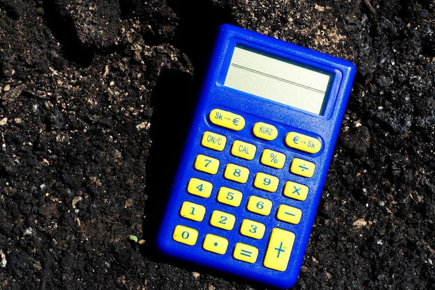 Foto blauwe rekenmachine in donkere bodem verbrand grond na de brand
