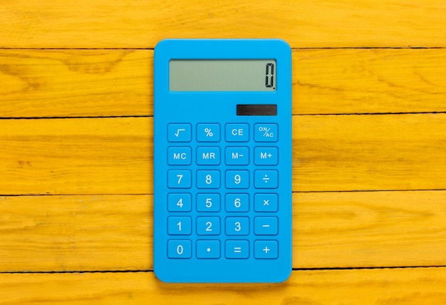 Blauwe rekenmachine op een gele houten