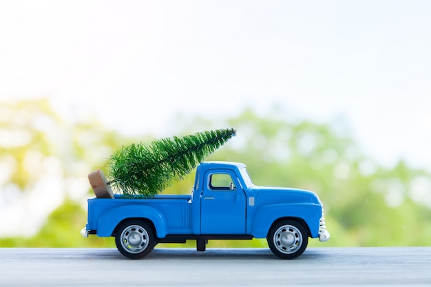 Blauwe retro speelgoedauto die Kerstmis of Nieuwjaarsgiften levert, die op wit worden geïsoleerd