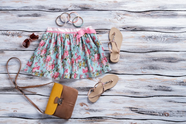 Blauwe rok met bloemenprint tweekleurige bruine portemonnee en sandalen damesaccessoires op winkel showcase qu...