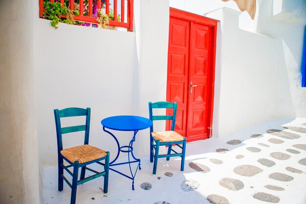 Blauwe stoelen en lijst op straat van typisch Grieks traditioneel dorp met witte huizen op Mykonos-Eiland, Griekenland, Europa