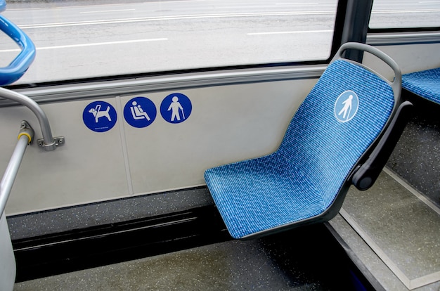 Blauwe stoffen stoel in de bus voor ouderen met een handicap en passagiers met kinderen.