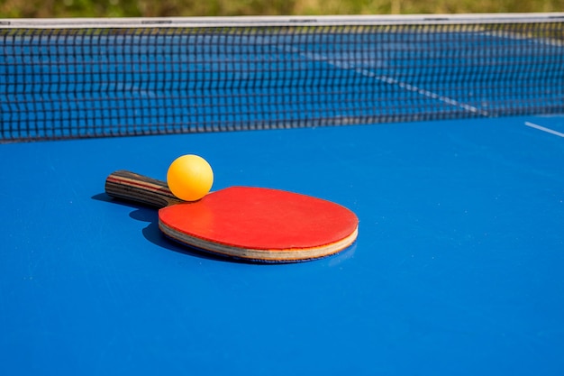 Blauwe tafeltennis of pingpong Outdoor tablettennis Closeup pingpong accessoires voor tafeltennis racket en bal op een blauwe tennistafel Sport