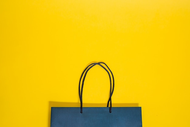 Blauwe tas met handvatten op een gele geïsoleerde achtergrond