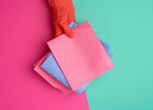 Blauwe viscose doek voor het reinigen van stof in huis met een oranje handschoen