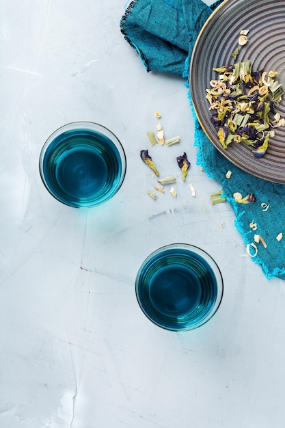 Blauwe vlinder erwt bloemen thee in een glas op tafel