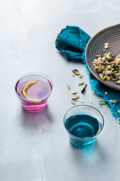 Blauwe vlinder erwt bloemen thee in een glas op tafel