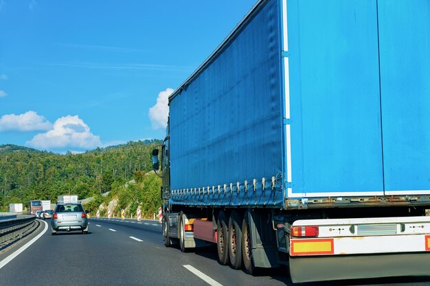 Blauwe vrachtwagen in de asfaltweg van Polen. Vrachtwagenvervoer die wat vrachtlading levert.