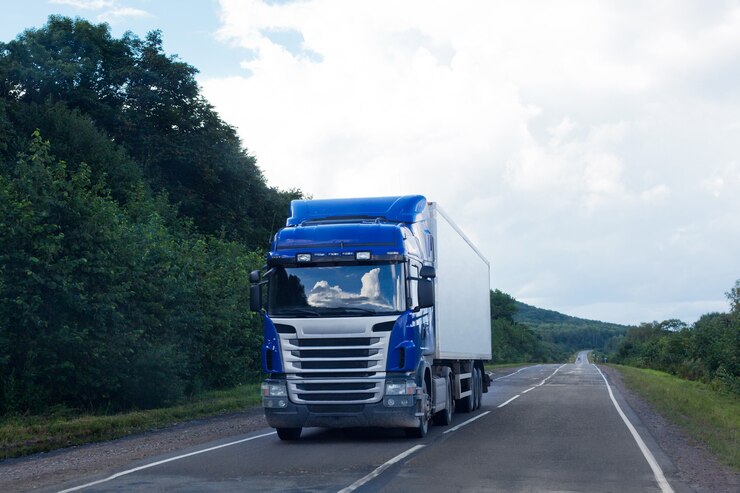 Blauwe vrachtwagen op een natte weg