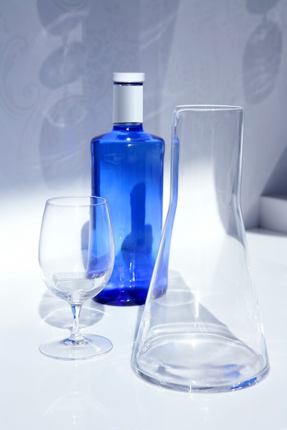 Blauwe waterfles met glas, transparante schaduw