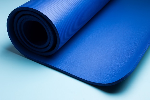 Blauwe yogamat. Apparatuur voor yoga. Concept gezonde levensstijl en sport.