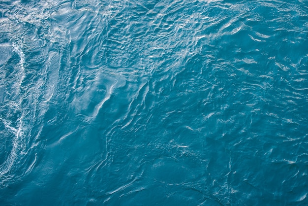 Foto blauwe zee-oppervlak met golven en rimpelingen. bovenaanzicht.