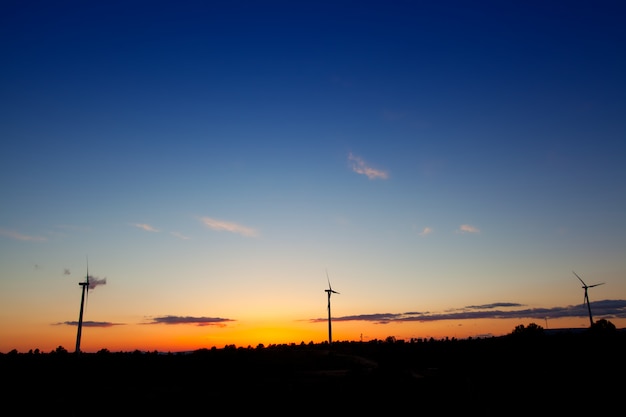 Blauworanje zonsondergang met elektrische windmolens