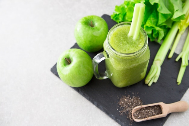 Blended green smoothie with ingredients. 