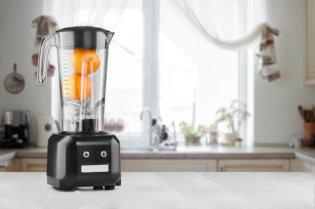 Blender and orange on wooden table in kitchen. Make yourself fresh. The concept of a healthy diet