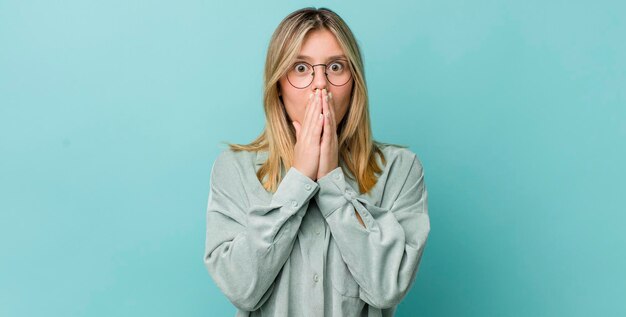 Blij en opgewonden verrast en verbaasd de mond bedekken met handen giechelen met een schattige uitdrukking