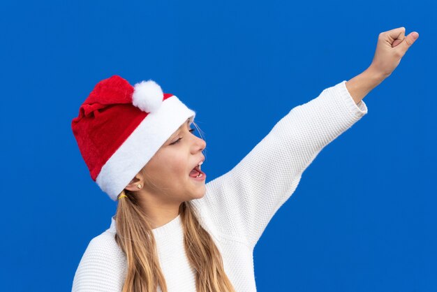 Blij Jong meisje in het gebaren van de Kerstmanhoed.