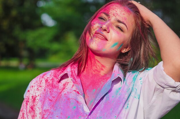 Blij Kaukasisch brunette meisje speelt met roze droge verf op het Holi-festival