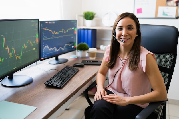 Blij om als effectenmakelaar te werken. Portret van een aantrekkelijke jonge vrouw freelance met een headset die aan haar bureau zit