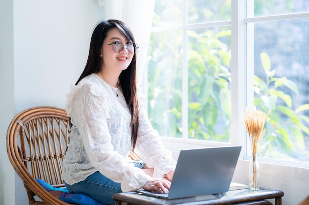 Blij van aziatische freelance mensen zakelijke vrouwelijke casual werken met laptopcomputer met koffiekopje en smartphone in coffeeshop zoals het backgroundcommunication concept