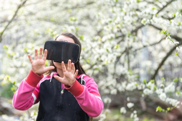 Blij verbaasd klein meisje met een virtual reality-bril die films kijkt of videogames speelt. Vrolijk verrast kind dat in een VR-bril kijkt en gebaren maakt