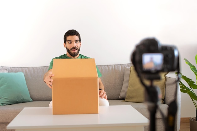 Blij verraste jonge blogger uit het Midden-Oosten aan tafel pakt video uit met kartonnen doos