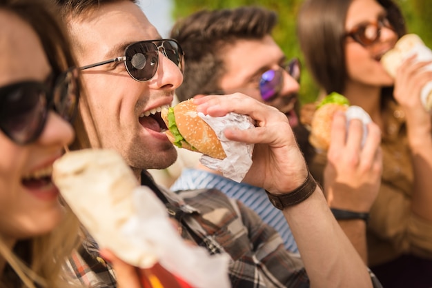 Blij zitten in het park en eet fastfood met vrienden.