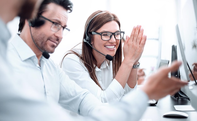 Blije callcentermedewerkers zitten aan hun bureau