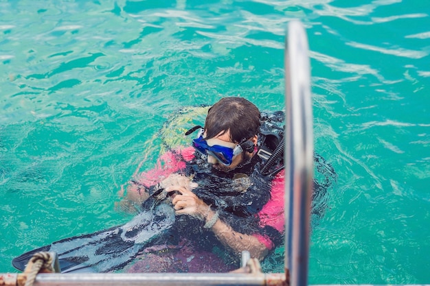 Foto blije duiker keert terug naar het schip na het duiken