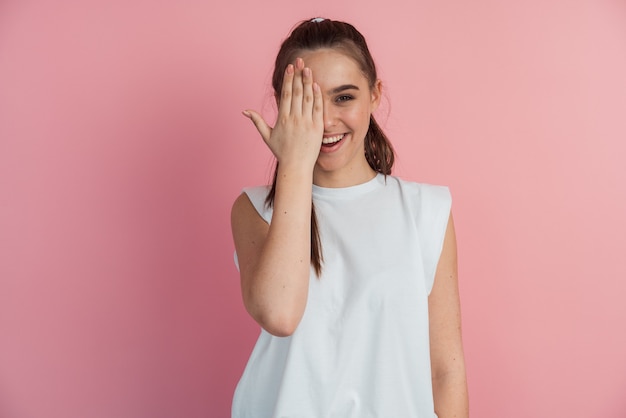 Blije, glimlachende vrouw met één oog, met de hand gesloten