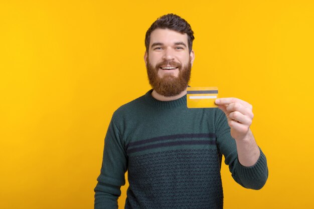 Blije jonge gelukkig man met zijn creditcard