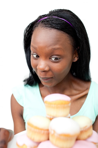 Blije jonge vrouw die cakes bekijkt