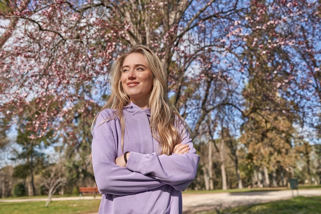 Blije jonge vrouw onder mooie bloeiende boom