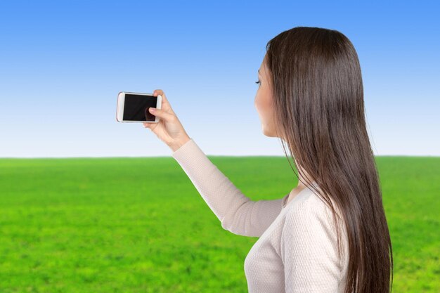 Blije jonge vrouwen die selfie door haar slimme telefoon maken