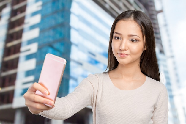 Blije jonge vrouwen die selfie door haar slimme telefoon maken